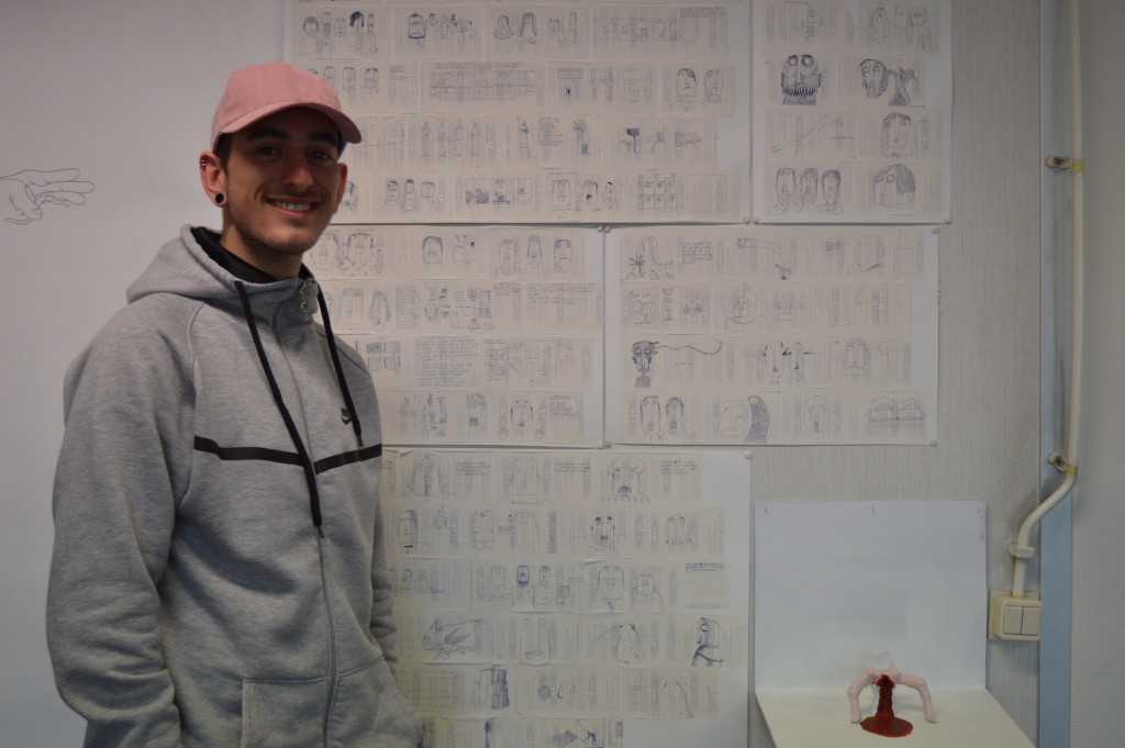 Matteo laat in zijn atelier een wand van illustraties op de achterkant van Actionbonnetjes zien.